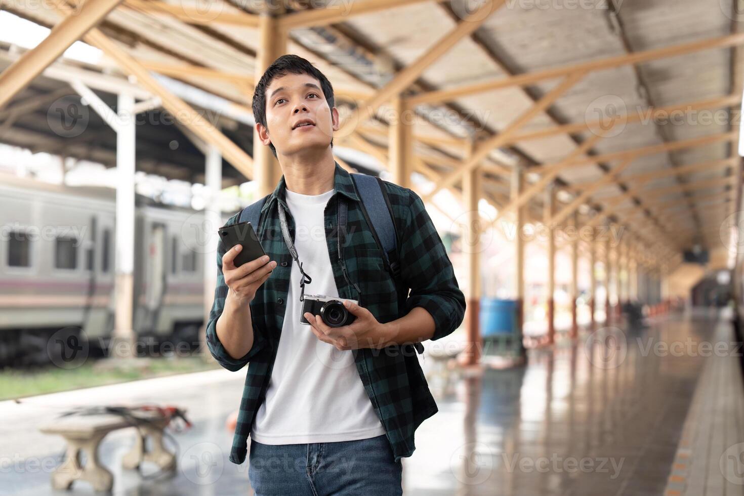 Exploration and Adventure. A traveler looks up at the train station while planning his next destination. photo