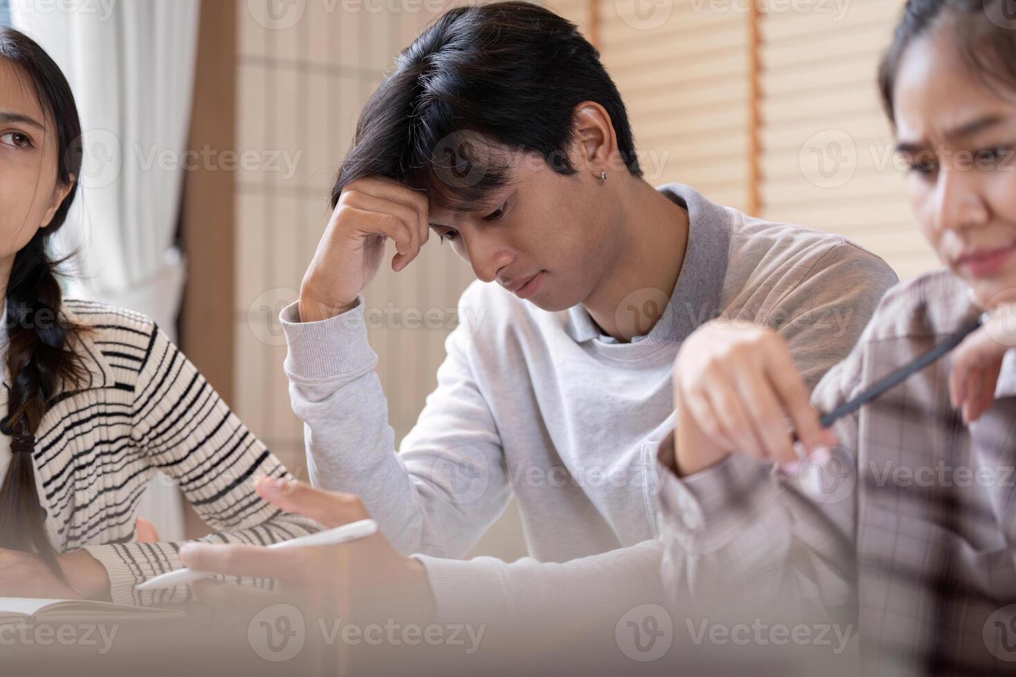 Concentration and Problem Solving. A student reflecting while working through challenging study material. photo