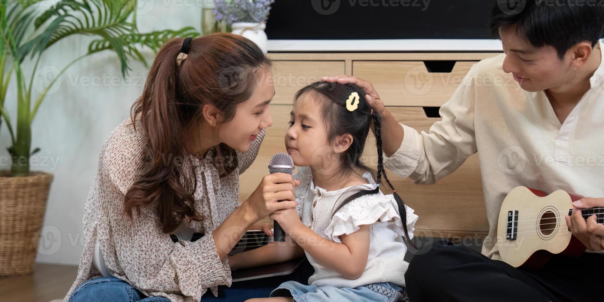 Family Bonding and Music. A mother and daughter duet with a microphone and ukulele at home. photo