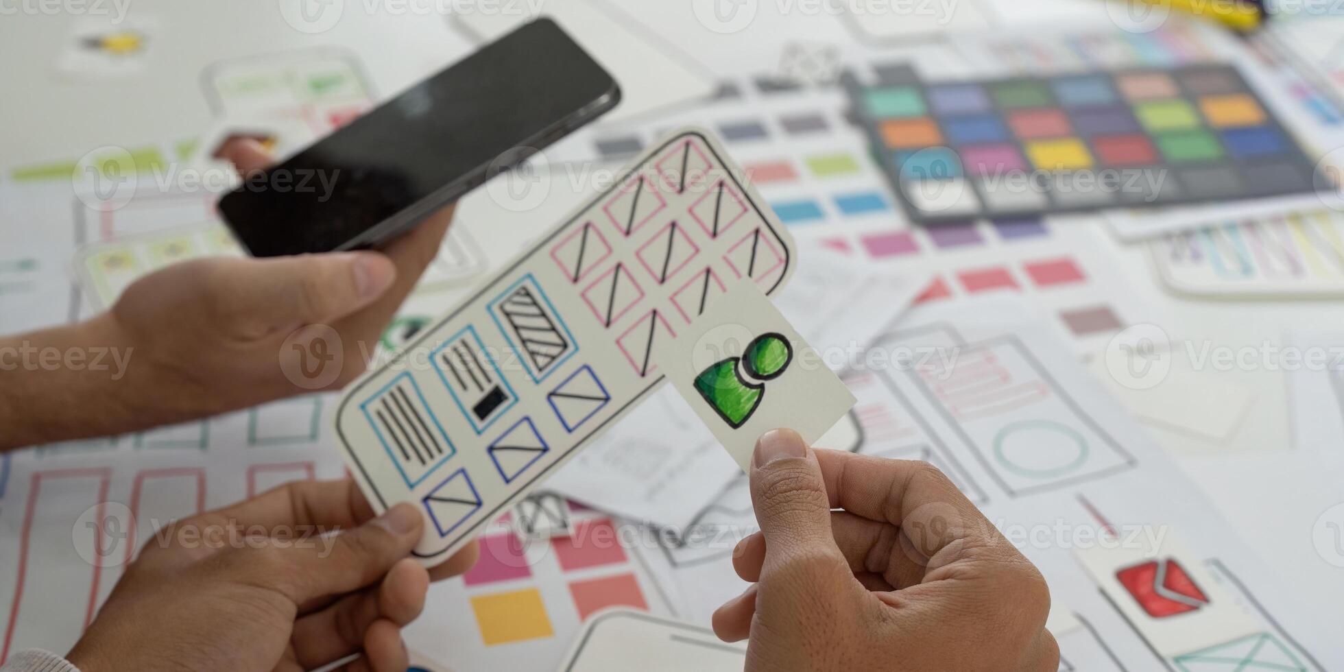 Prototyping and Mobile App Design. Collaborators analyzing wireframes and sketches for a mobile application. photo