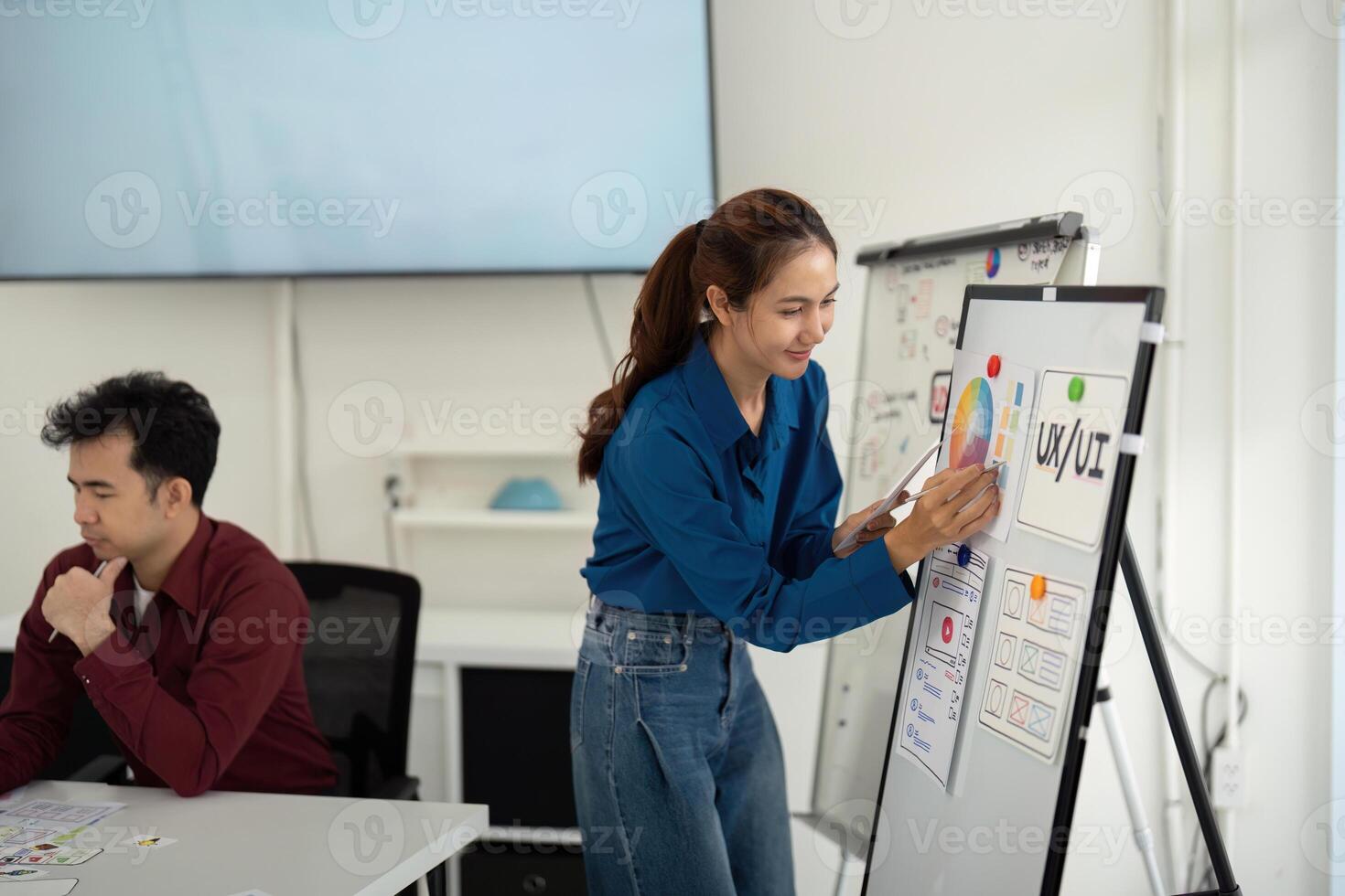 Creative Presentation in UX UI. A designer engages with a flip chart to present design concepts to her team. photo