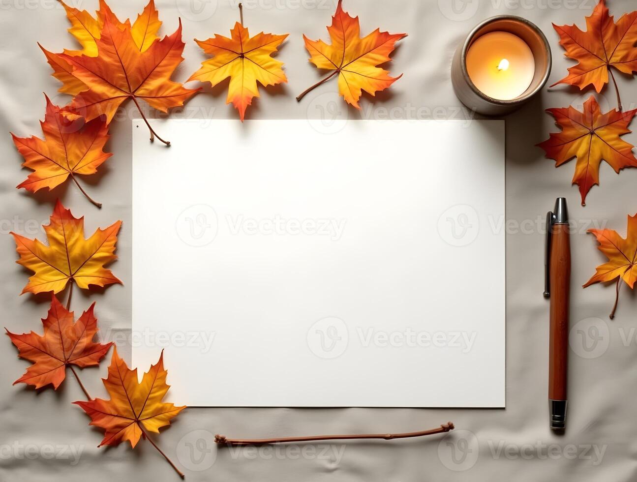 Blank paper with autumn leaves, pen, candle on a soft fabric background photo