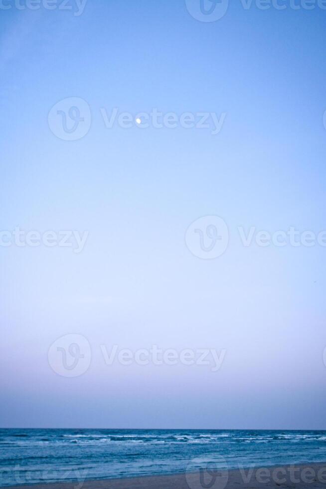 Moon in the sky in front of the beach on the island of Usedom on the Baltic Sea photo