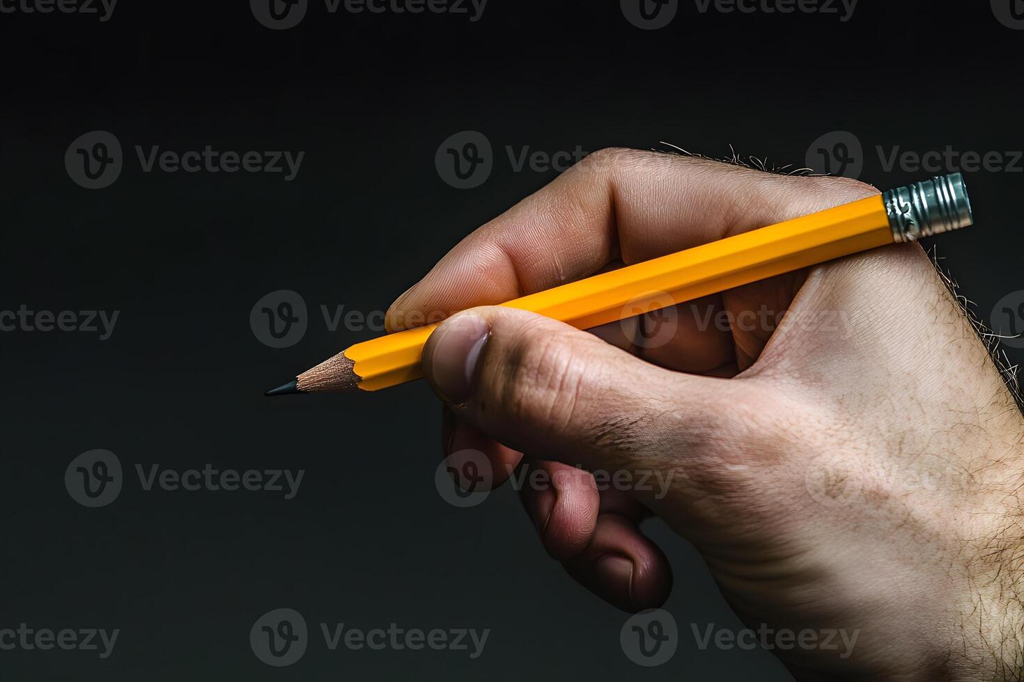 Close up of a Man s Hand Holding a Sharpened Yellow Pencil Ready to Write or Draw photo