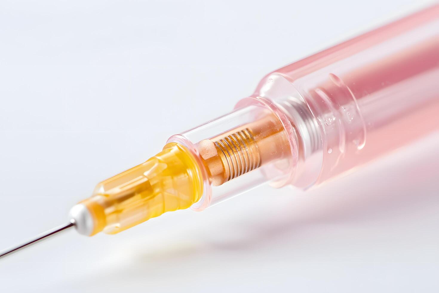Close up of Medical Syringe with Pink Barrel and Yellow Plunger Sterile Injection Device photo
