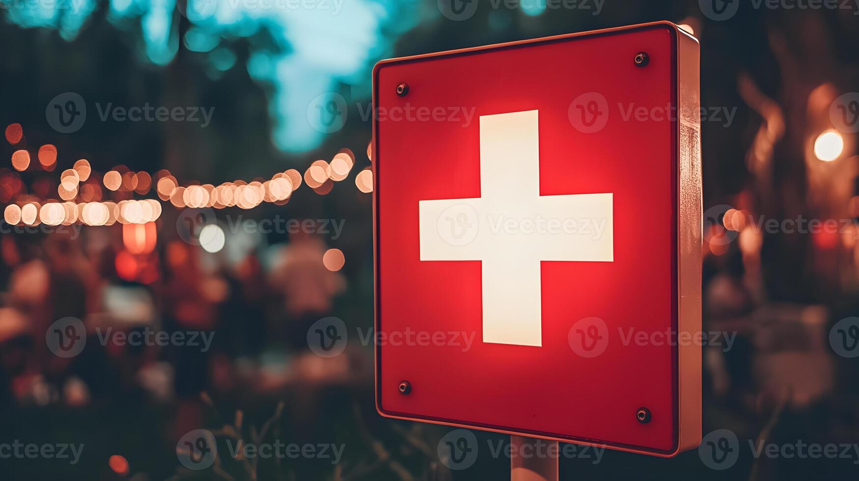 Illuminated Red First Aid Sign at Nighttime Outdoor Event with Bokeh Background photo