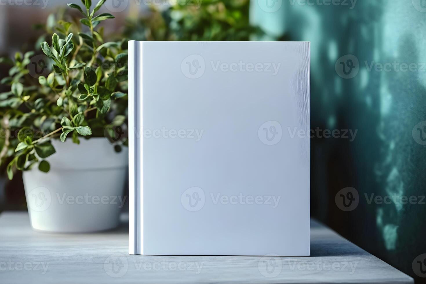 Blank notebook for mockup resting on a wooden table next to a green plant in a bright, serene space with soft natural light illuminating the scene photo