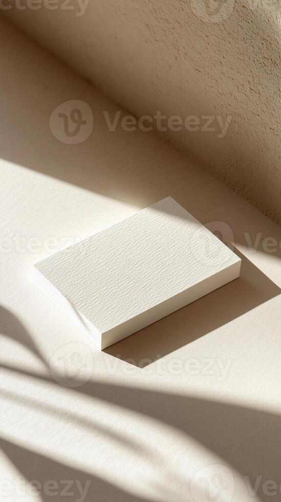 Minimalist white business card for mockup in soft sunlight on a beige surface with delicate shadows reflecting a tranquil atmosphere and simple design photo