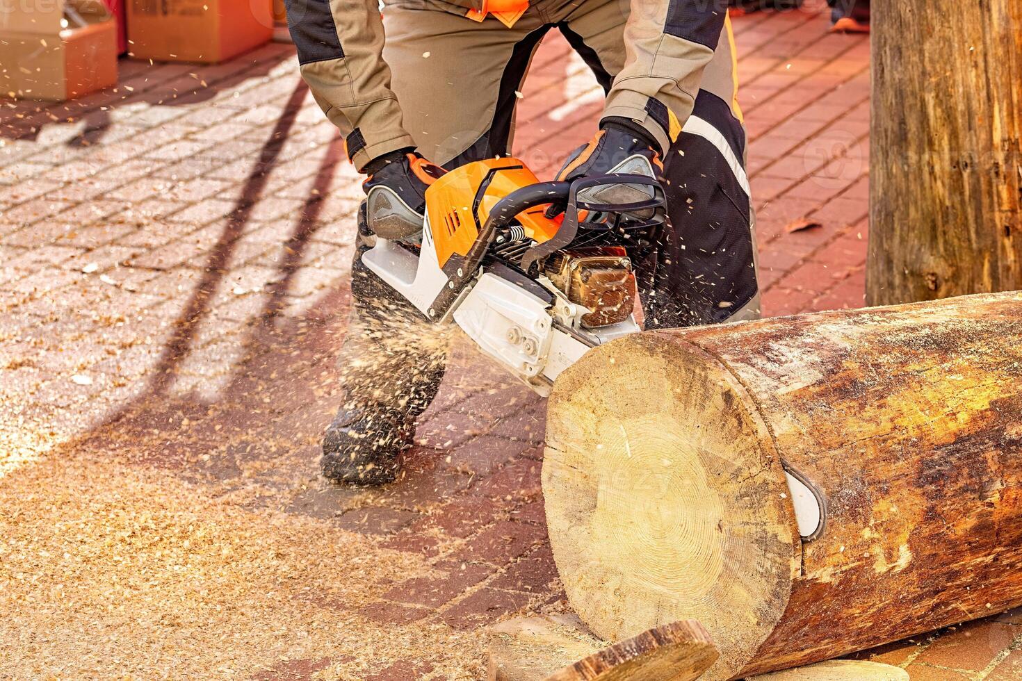 Expert woodworker skillfully cuts into a log using a high-powered chainsaw on a sunny afternoon photo