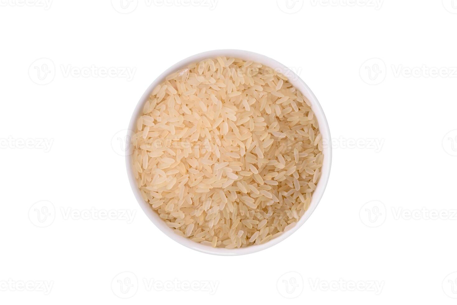 White raw rice in a ceramic bowl. Rice as an ingredient isolated on white photo
