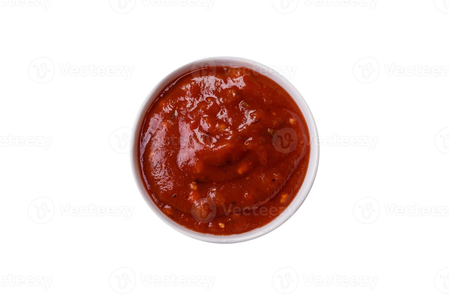 Red sauce or ketchup with spices in ceramic sauce boat photo