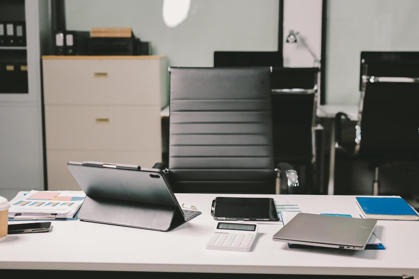 An office desk with a laptop, tablet and other items photo