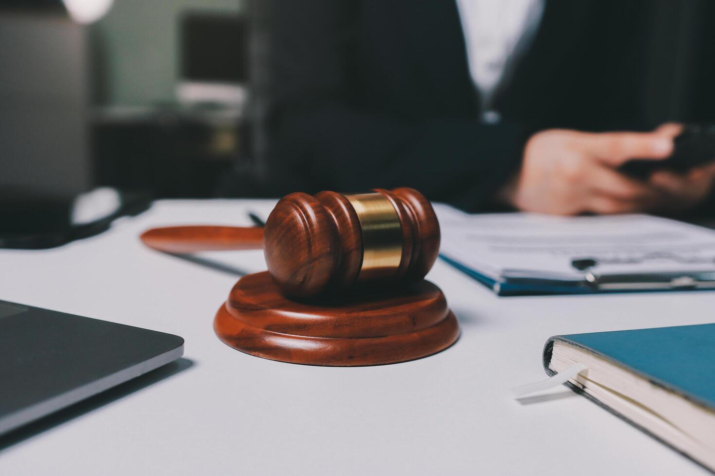 Lawyer and judge sitting at desk with a gavel and a laptop photo
