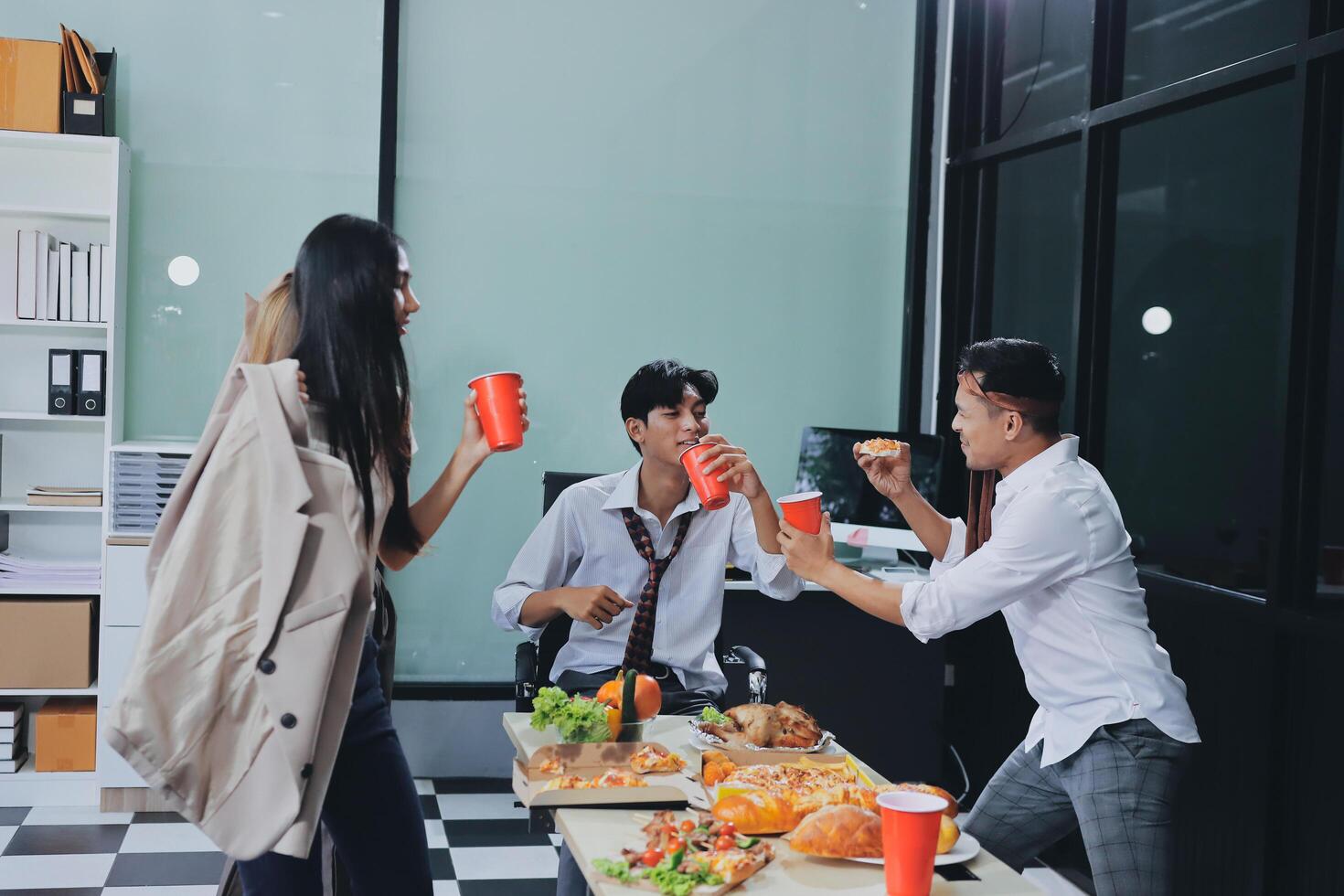Three people eating food in an office photo