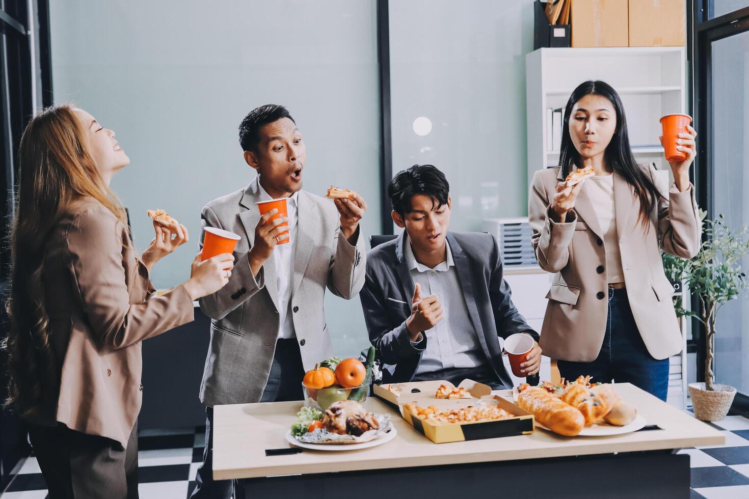 Group of people eating food in office photo
