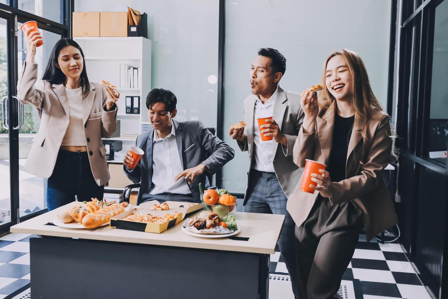 Asian business people enjoying food and drinks in office photo