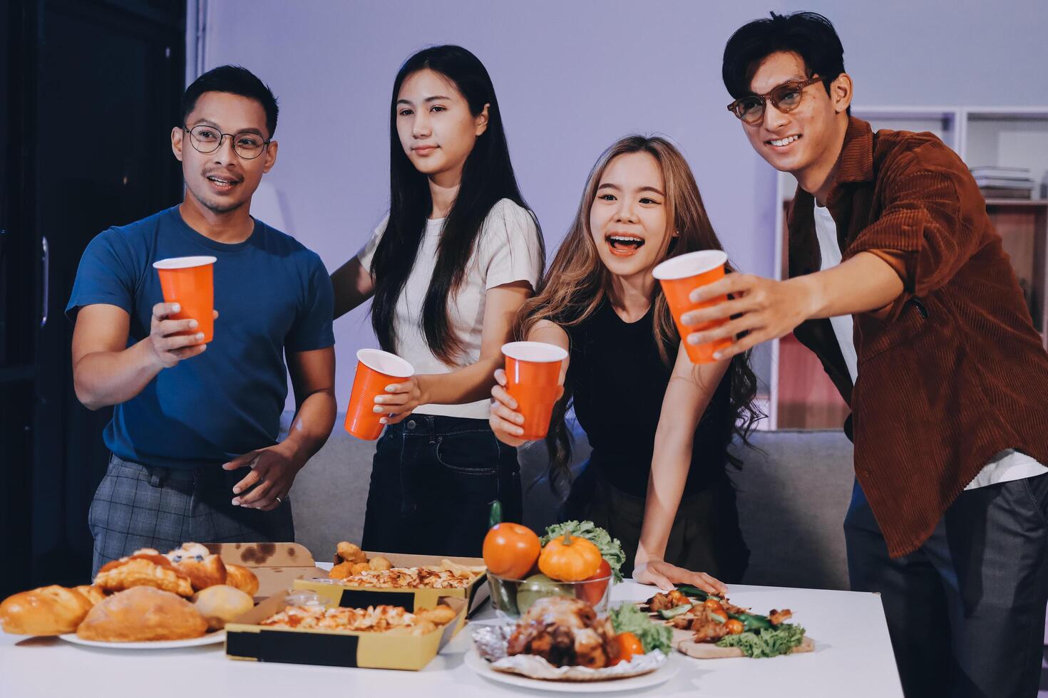 Four friends toasting with drinks at a table photo