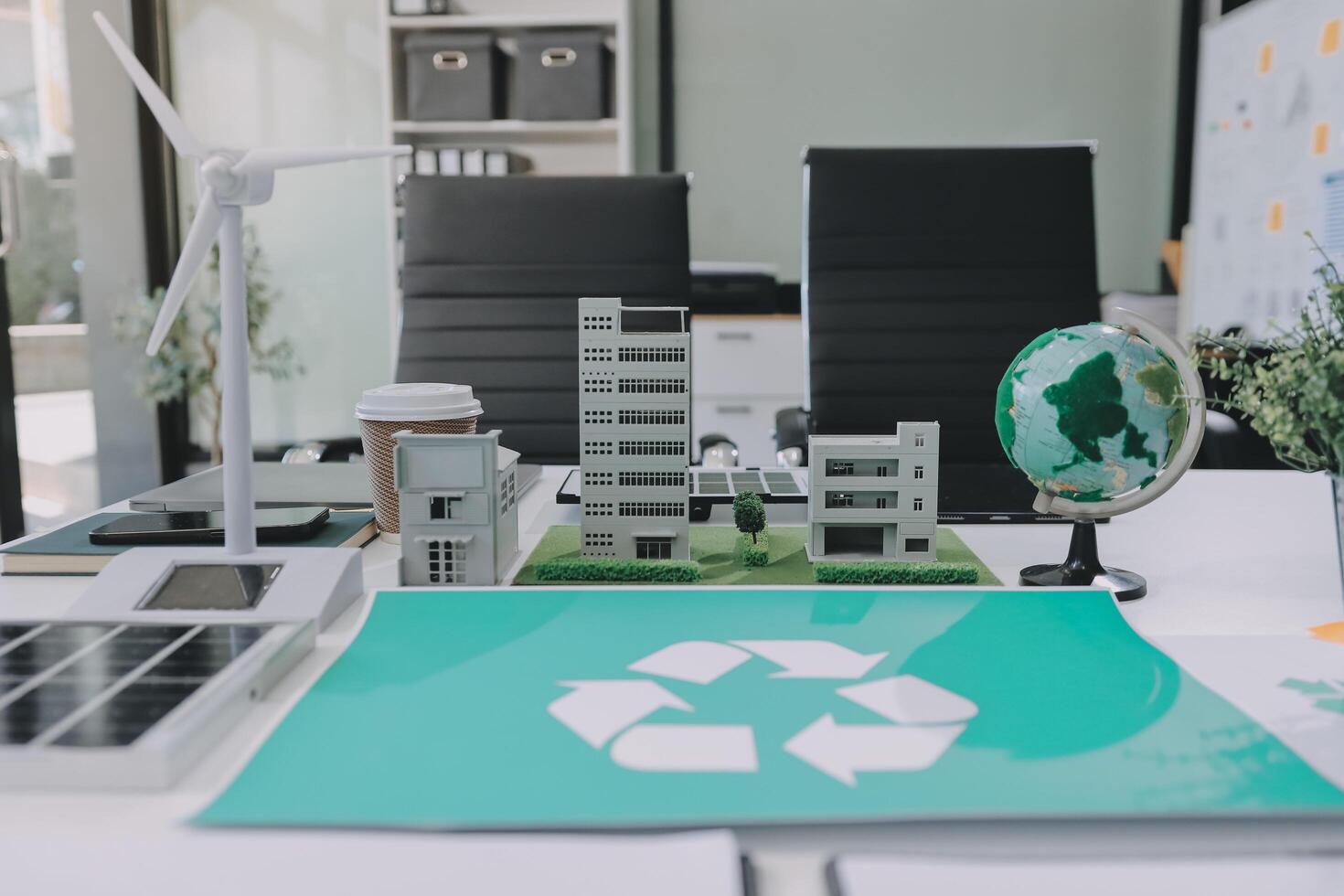A recycling symbol on a desk with a globe and a paper with a recycling symbol photo