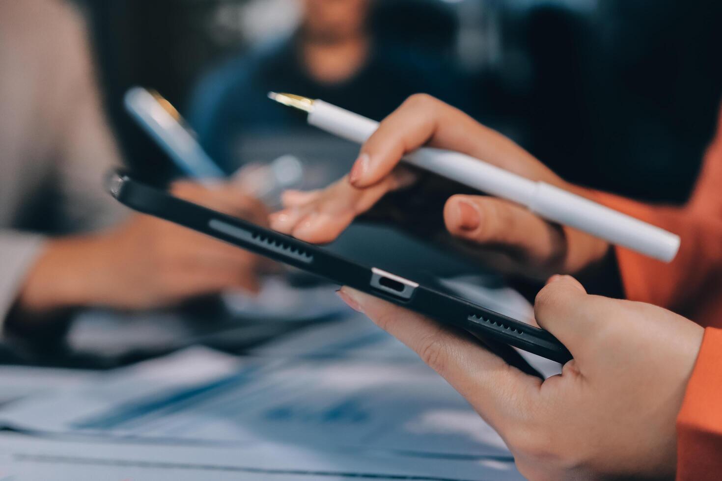A person holding a pen and using a tablet photo
