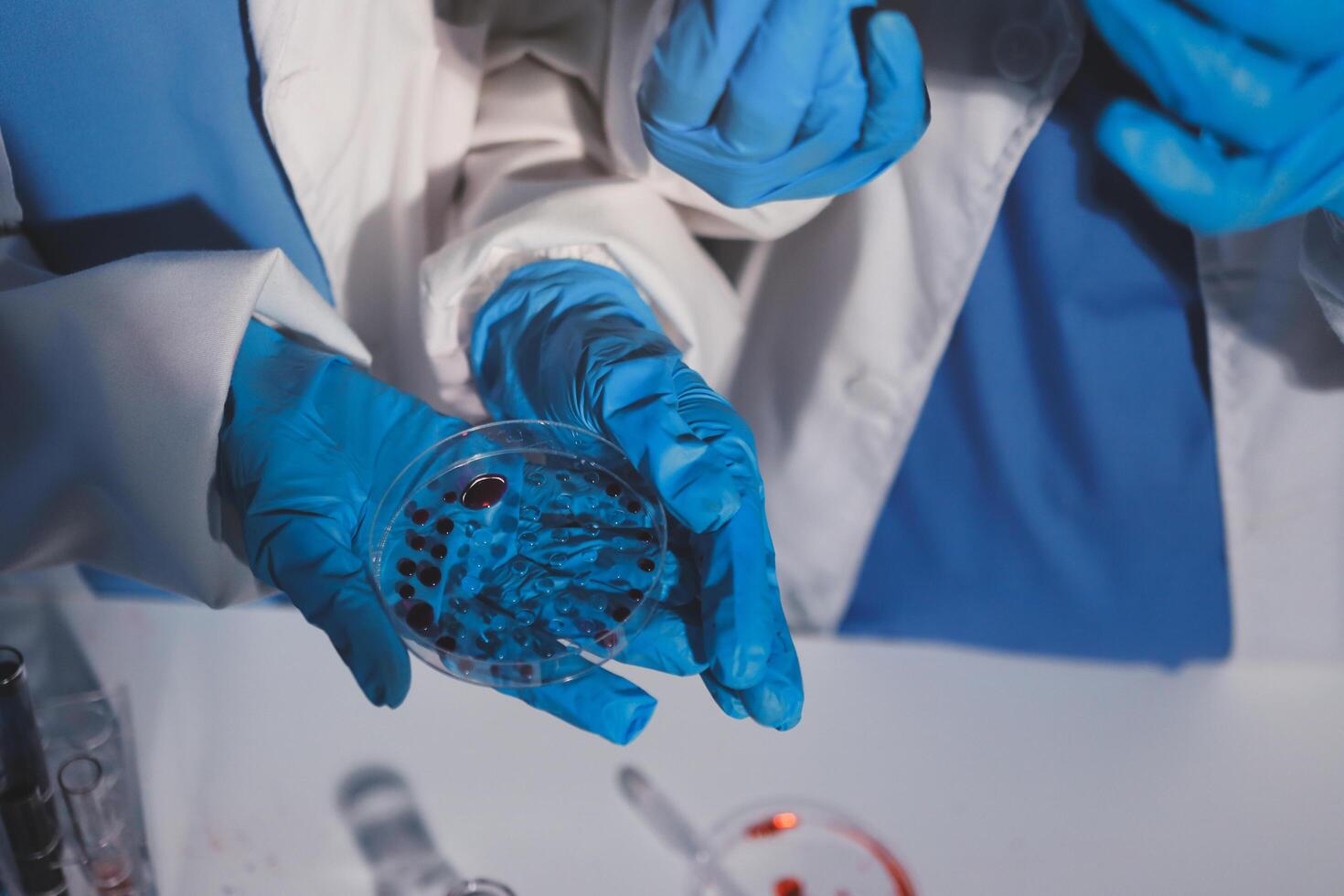 Two people in lab coats holding up a glass with blood photo