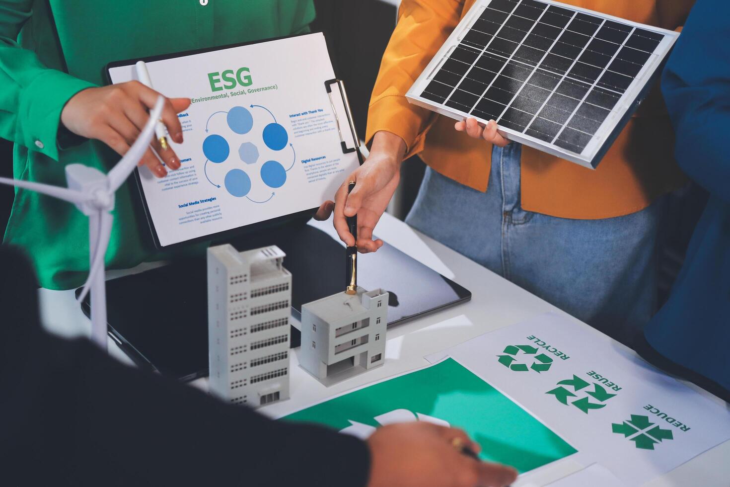 People working on a project with a green energy sign photo