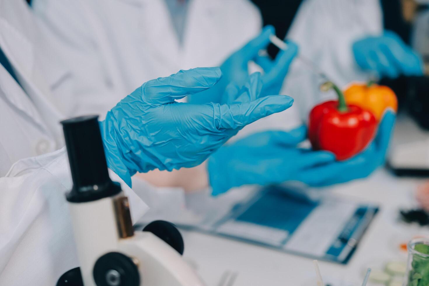 Scientists in lab coats holding up a pepper photo
