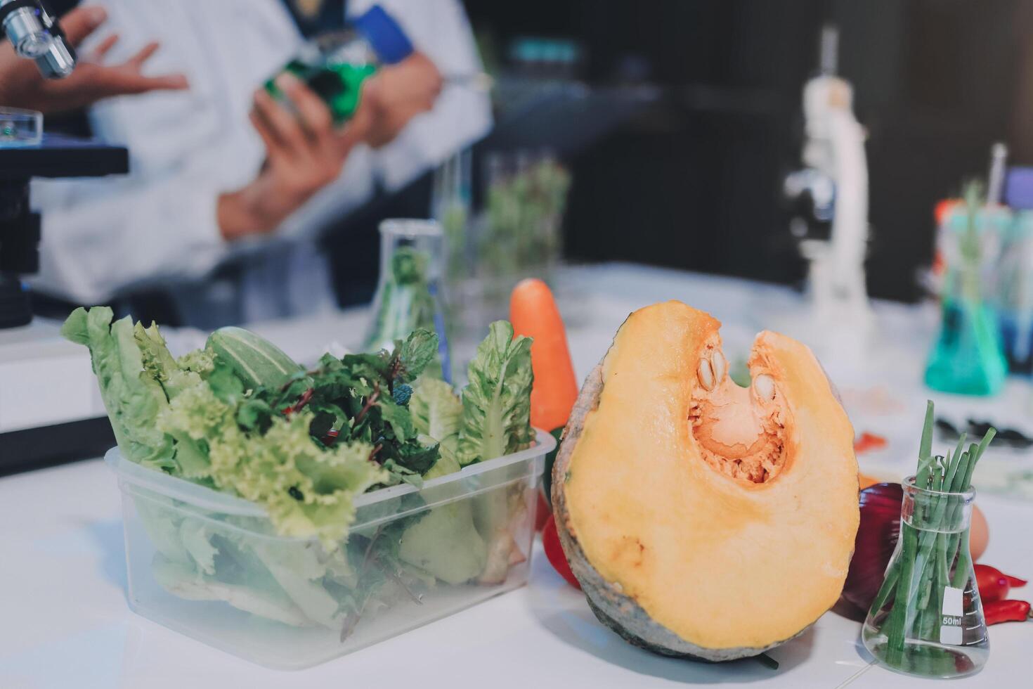 A table with vegetables and a man in lab coat photo