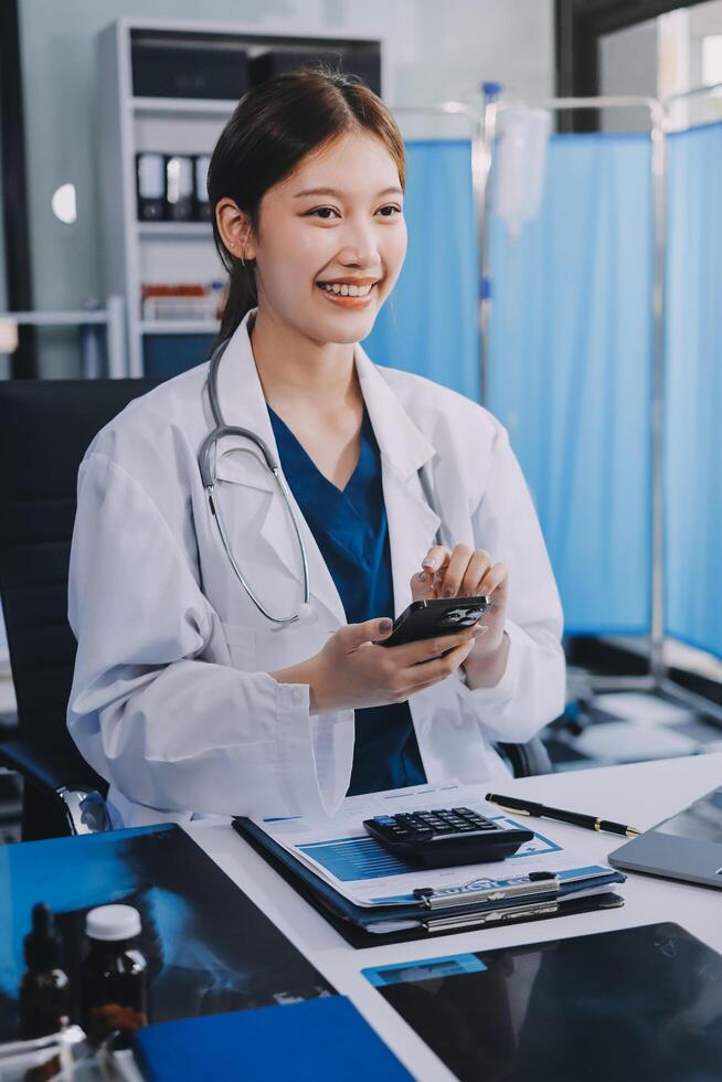 A woman in a lab coat is smiling while using her phone photo