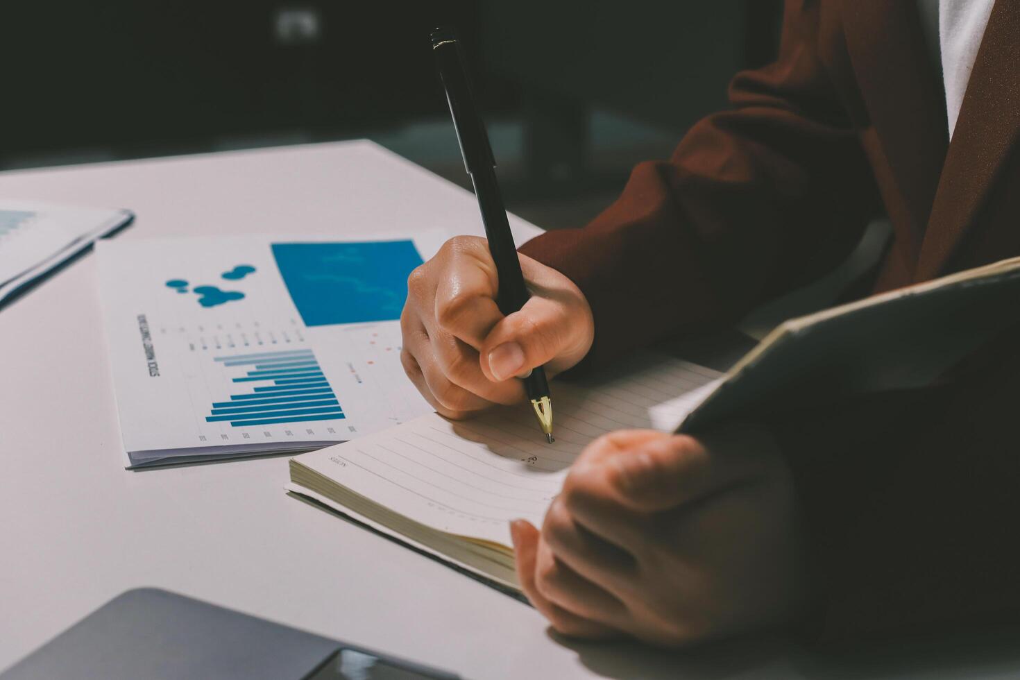A business person writing in a notebook with a pen photo