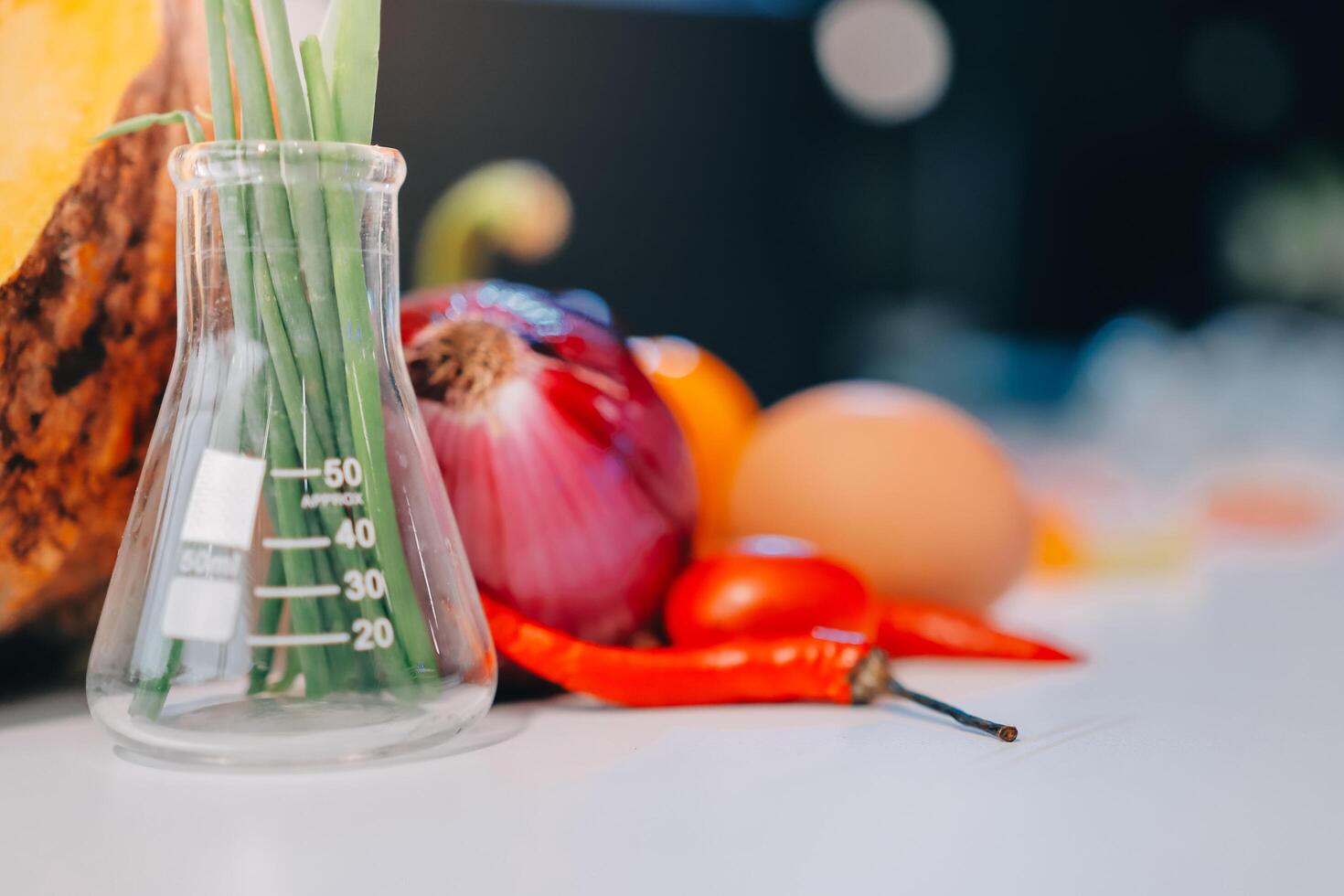 A glass flask with a test tube filled with vegetables photo