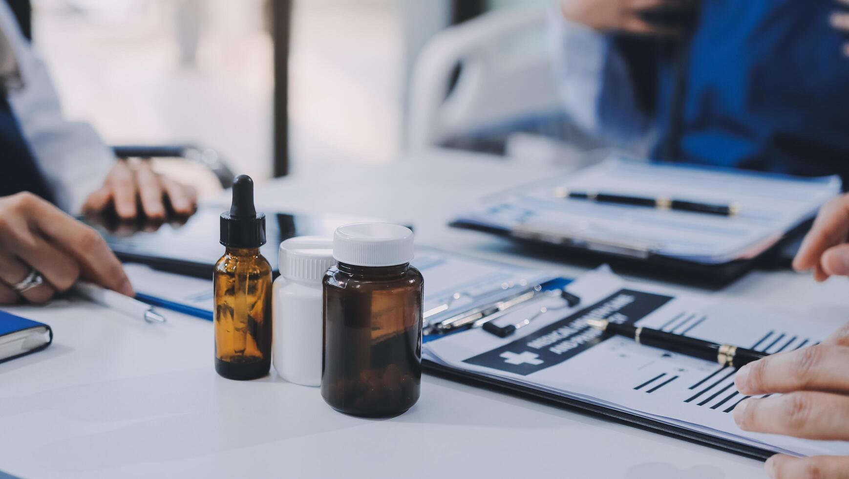 A group of people sitting around a table with bottles and pills photo
