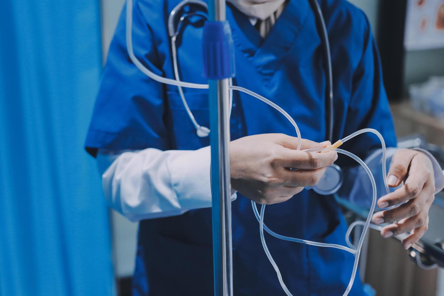 A nurse in blue scrubs holding a tube photo