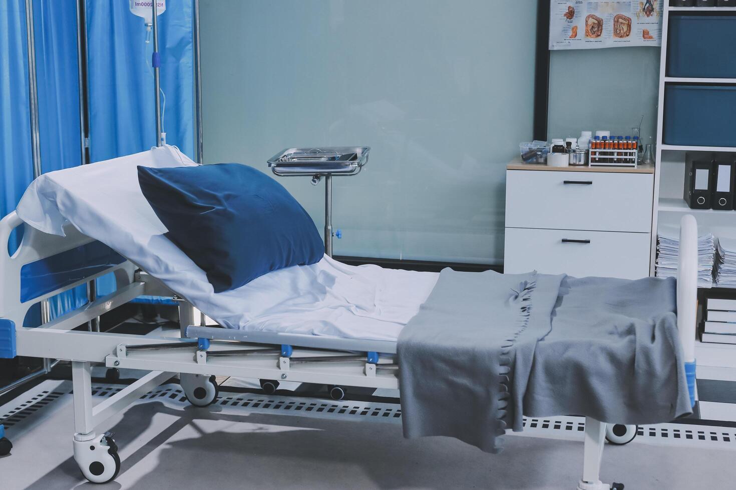 A hospital bed with blue sheets and a blue pillow photo