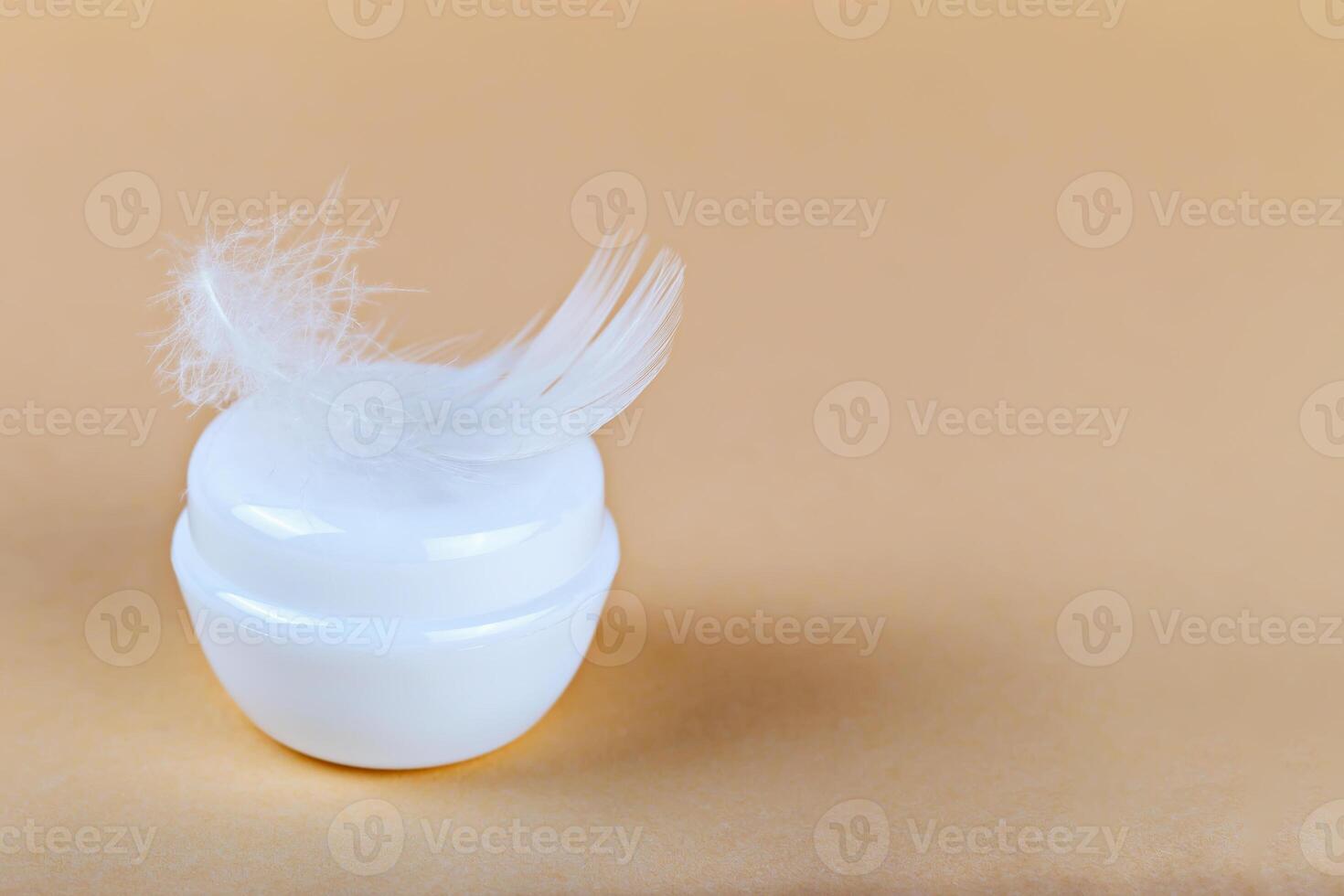Mockup. Cream jar decorated with white feather on soft pastel background. Cream conveys skincare softness concept. Cosmetic cream jar highlights beauty routine and delicate skincare luxury photo