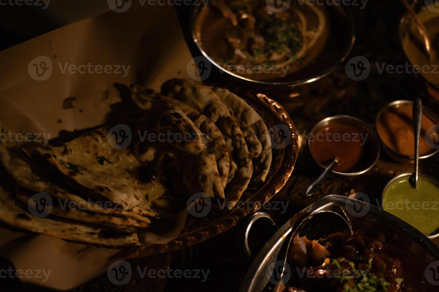 Indian dishes, tortillas and various sauces in plates on the table photo