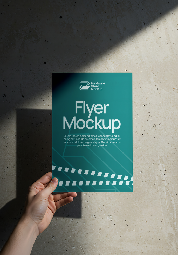 A hand holds up a teal flyer mockup against a concrete wall psd