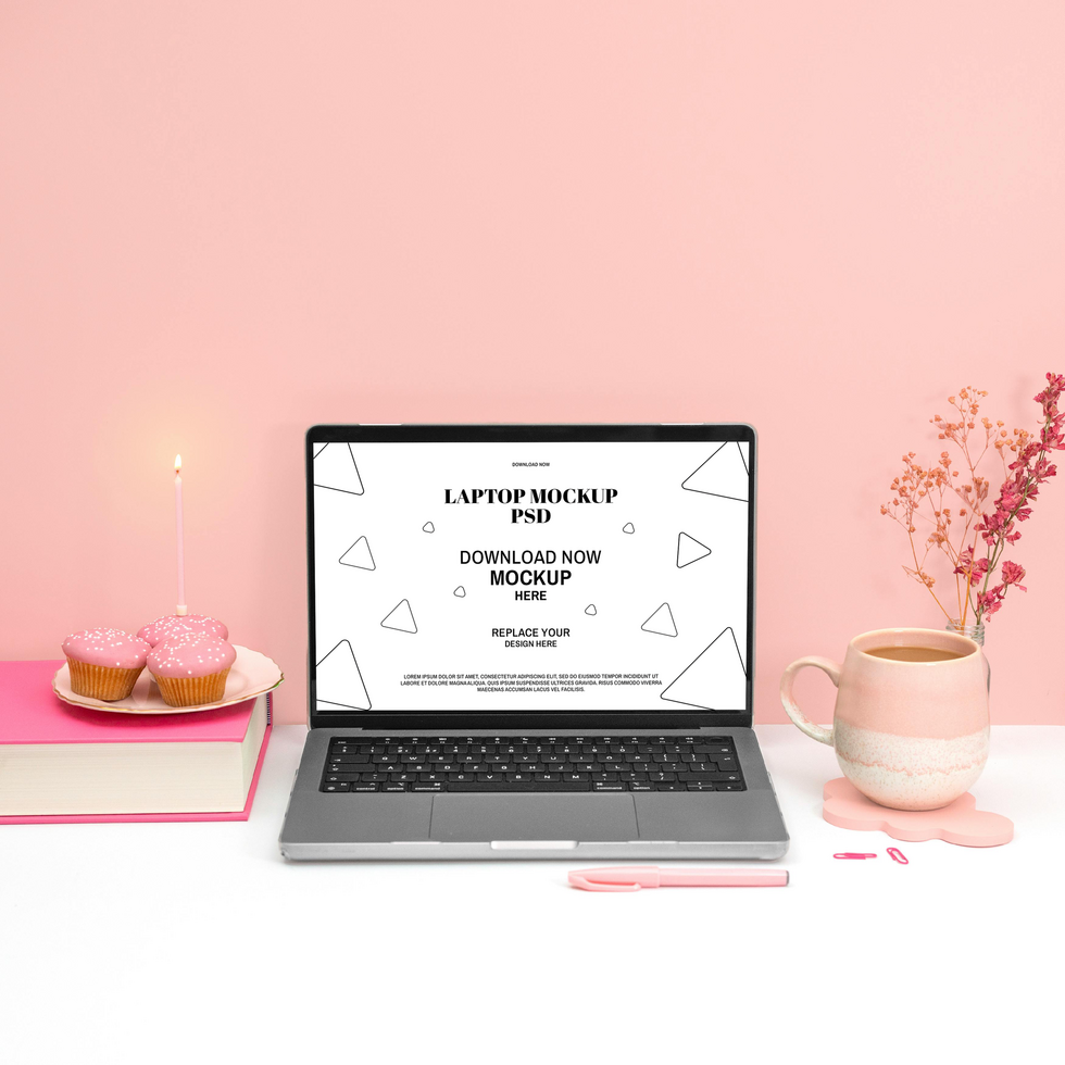 Laptop mockup on a pink aesthetic workspace with cupcakes and coffee psd