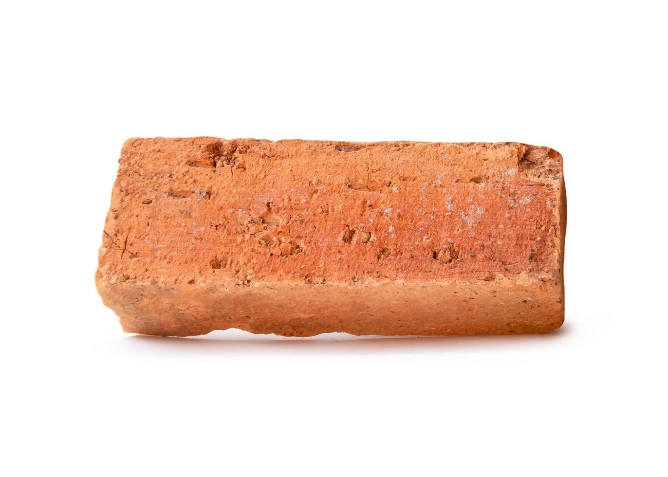 Side view of single cracked old red or orange brick isolated on white background with clipping path photo