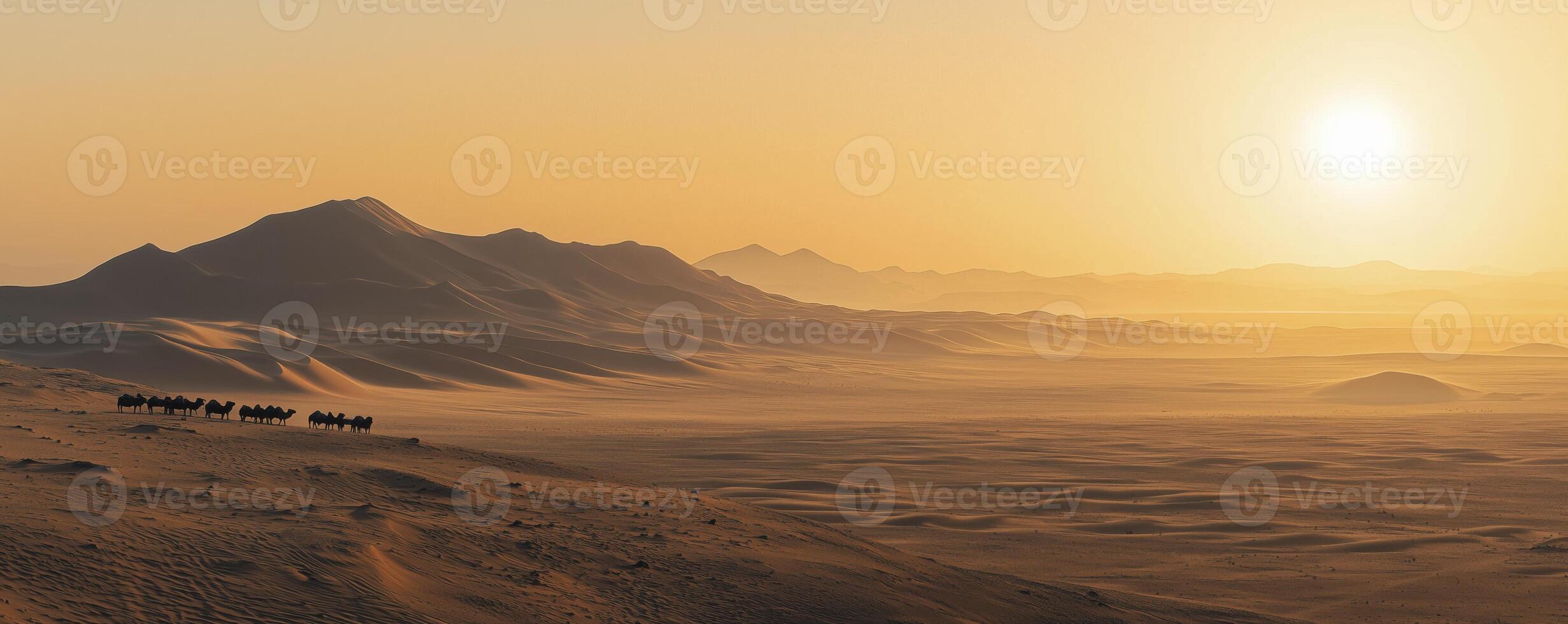Camel caravan crossing the vast desert dunes at golden sunset photo