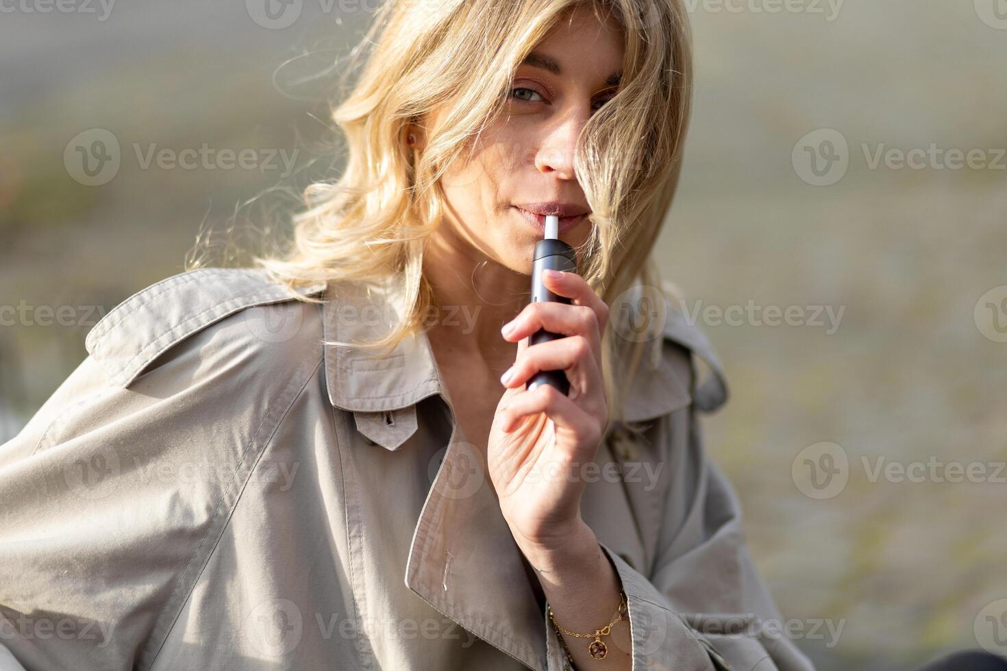 Stylish individual enjoying a vaping experience in a natural outdoor setting during daylight hours photo