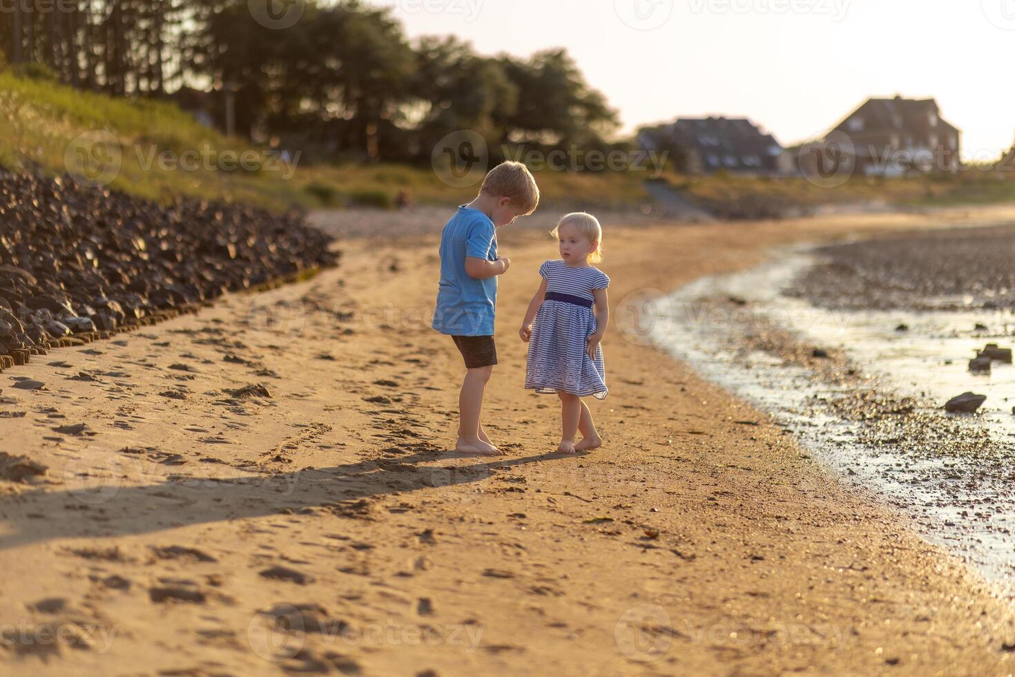 Children playing barefoot on the sand at the beach photo