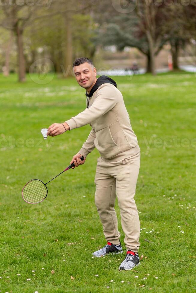 Man in sportswear holding badminton racket and shuttlecock. photo