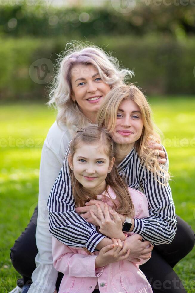 portrait of happy grandmother, mother and daughter against photo