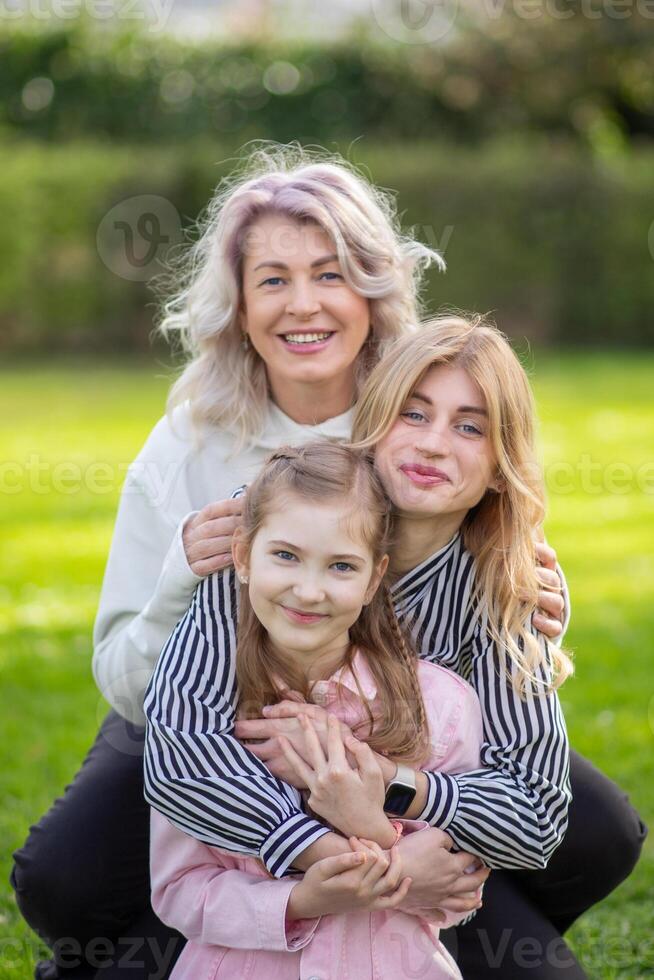 portrait of happy grandmother, mother and daughter against photo