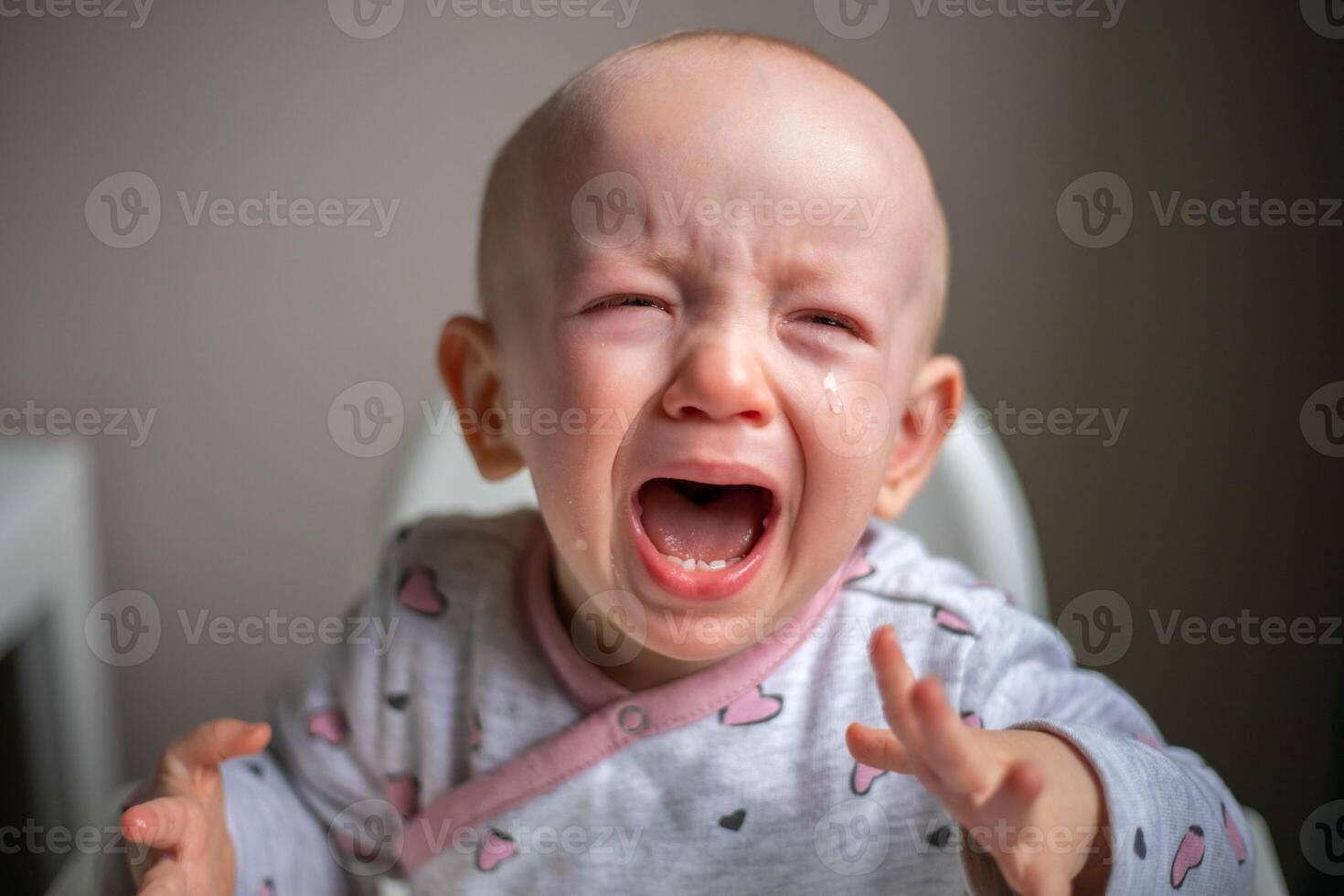Small child with tears his eyes is crying loudly with his mouth wide open photo