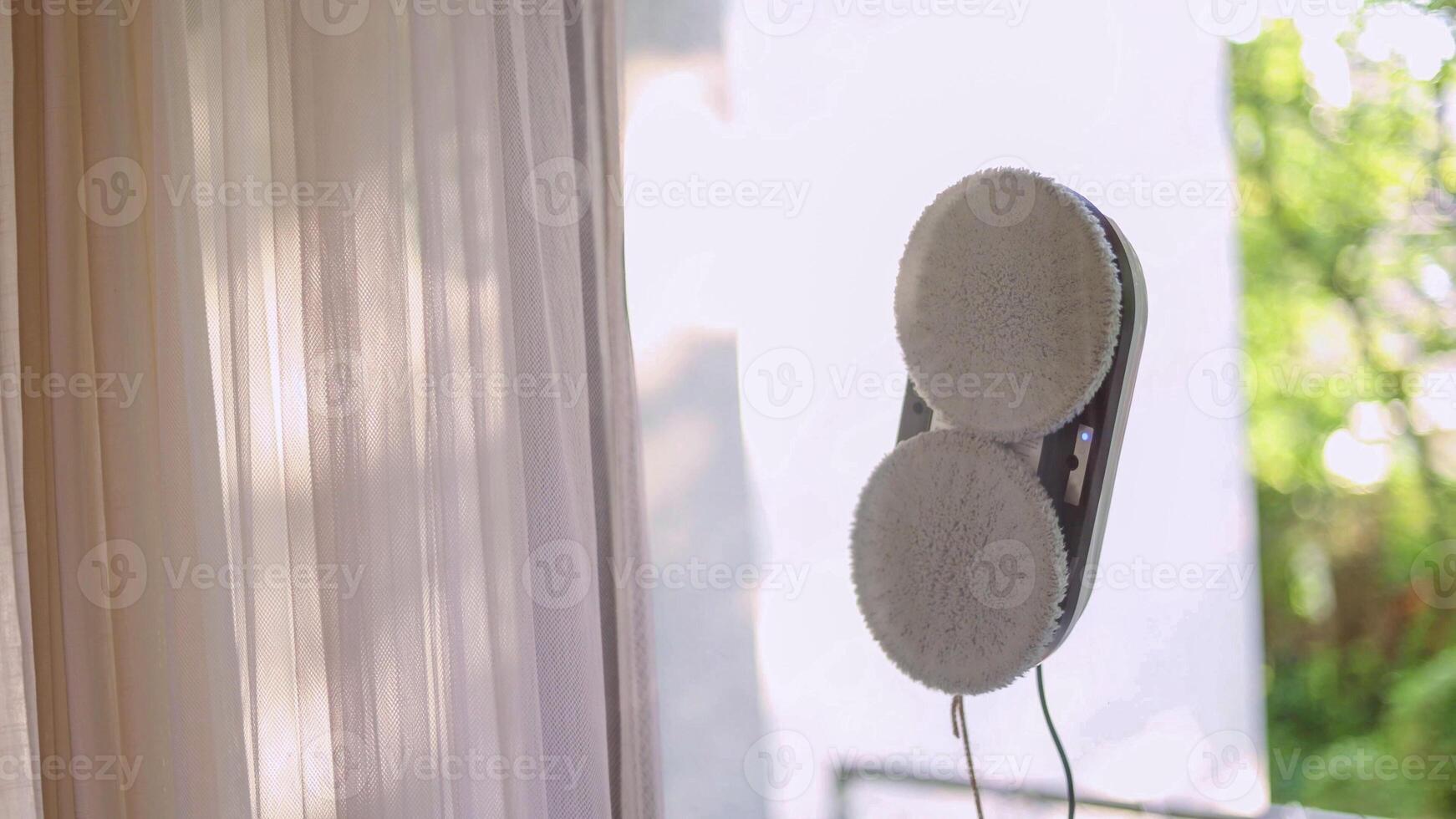Window cleaning robot with visible rotating brushes on glass. photo