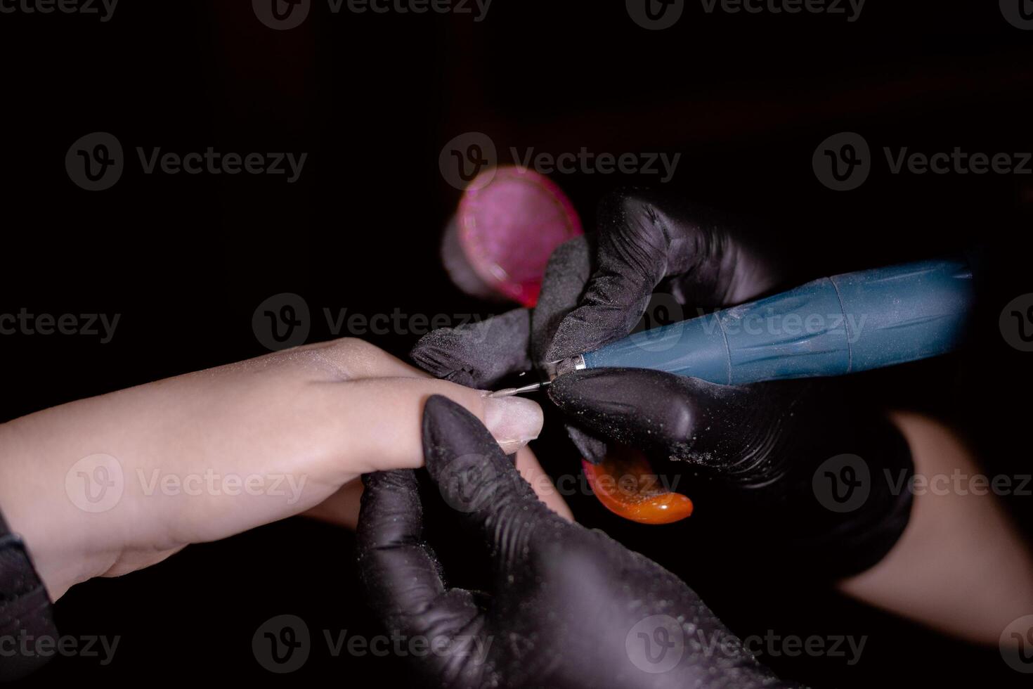 Professional manicure. Technician in black gloves using tool photo