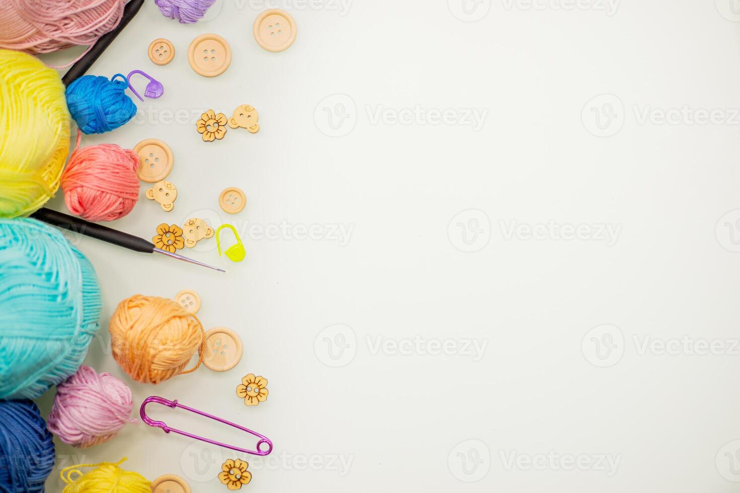 Flat lay composition with knitting threads and hook and buttons on white table, space for text, top view photo