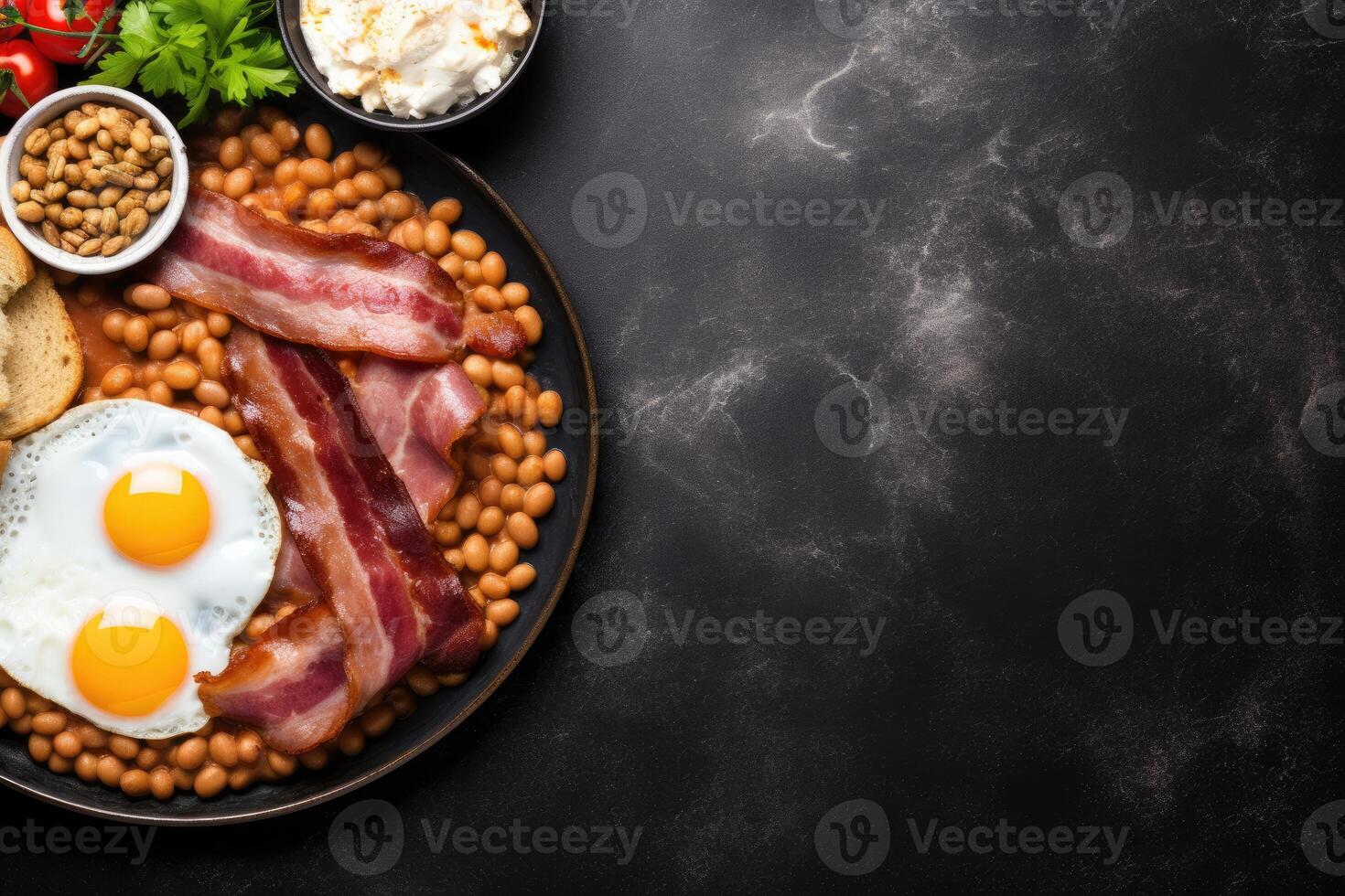 English breakfast on a plate with scrambled eggs, sausages, bacon, beans, toast and coffee on a dark stone background. photo