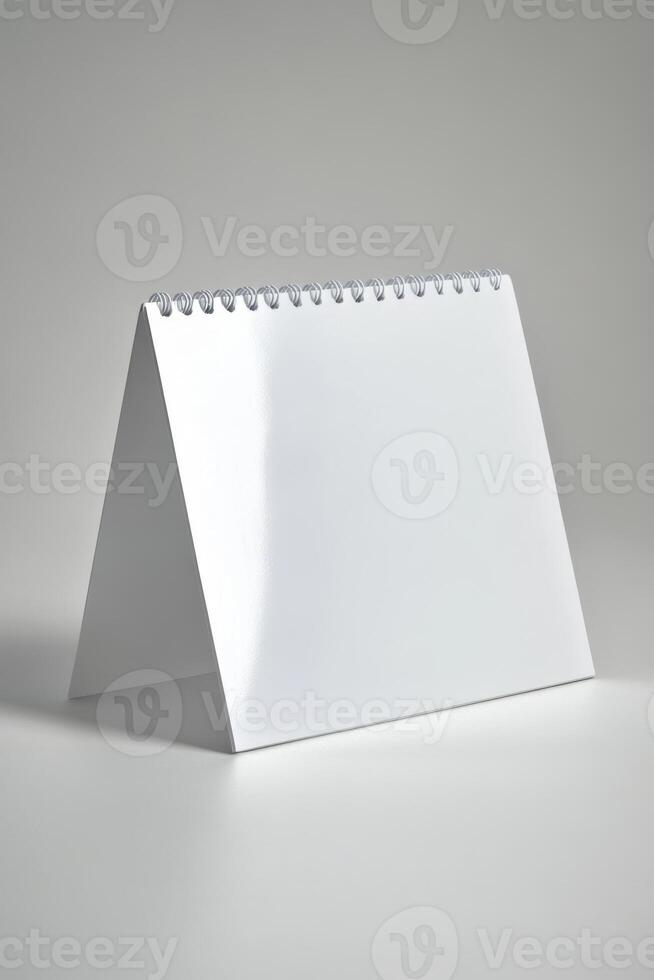 Blank tabletop calendar standing upright showcasing a minimalistic design against a neutral background photo